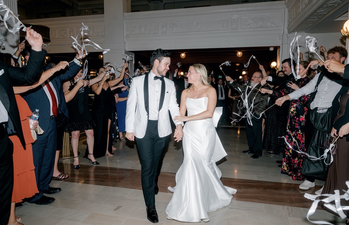 Newlyweds make a celebratory exit through cheering guests at The Gunter Hotel